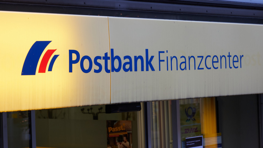 Die Aufschrift «Postbank Finanzcenter» steht über dem Eingang einer Postbank-Filiale in Hamburg-Eimsbüttel. Die jüngste Welle der Technik-Umstellung bei der Postbank hat manche Kundinnen und Kunden wieder Nerven gekostet.