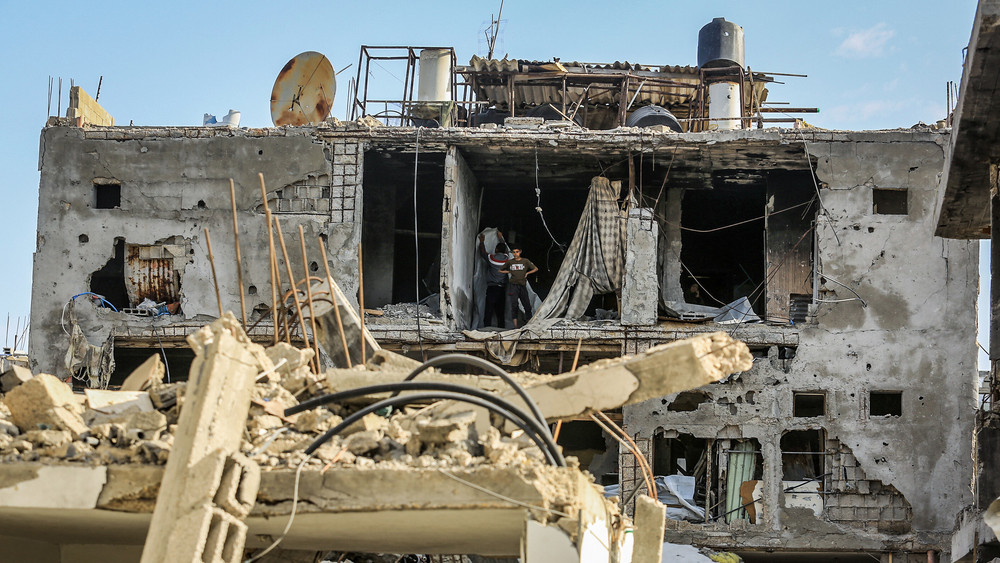 Bewohner des Gaza-Streifens suchen in den Trümmern ihre Habseligkeiten. 