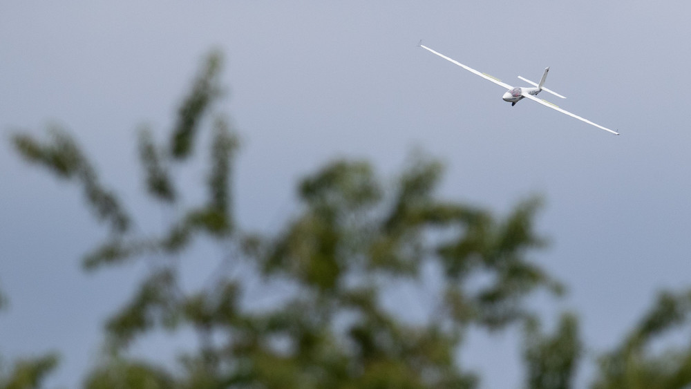 Ein Segelflieger fliegt beim Training an einem Flugplatz.