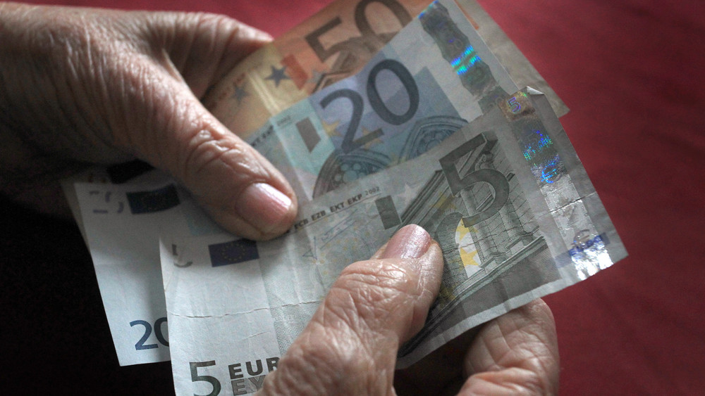 Geldscheine in den Händen einer älteren Frau.