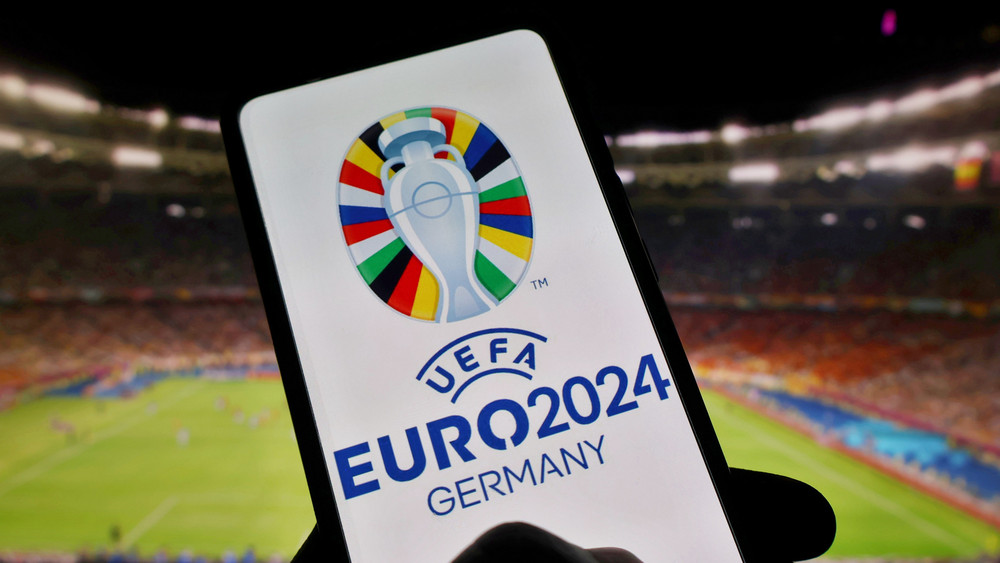 Logo der UEFA Euro 2024auf einem Smartphone im Stadion