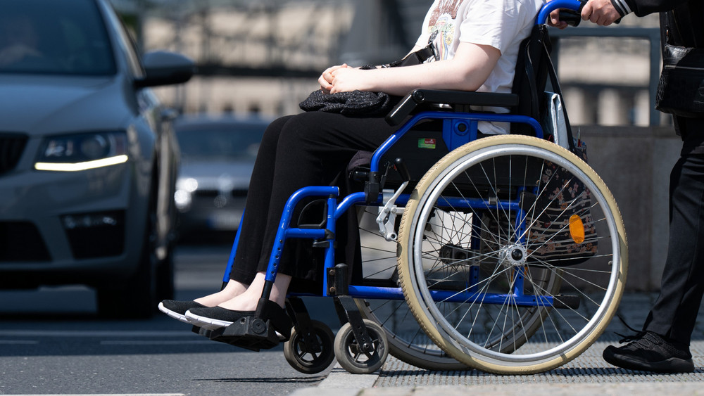 Eine Frau sitzt in einem Rollstuhl.
