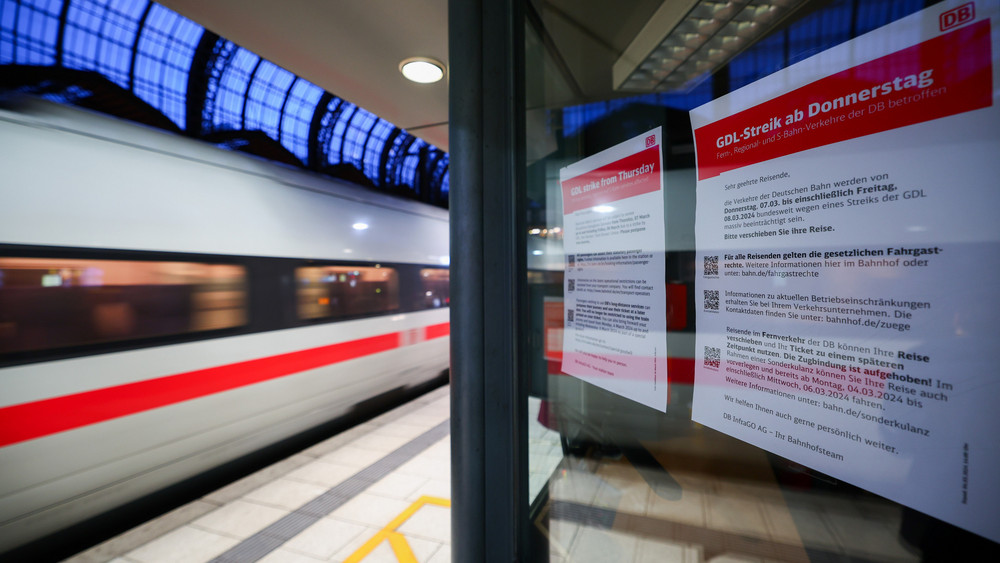 Bahnsteig mit durchfahrendem Zug, Hinweisschild auf GDL-Streik