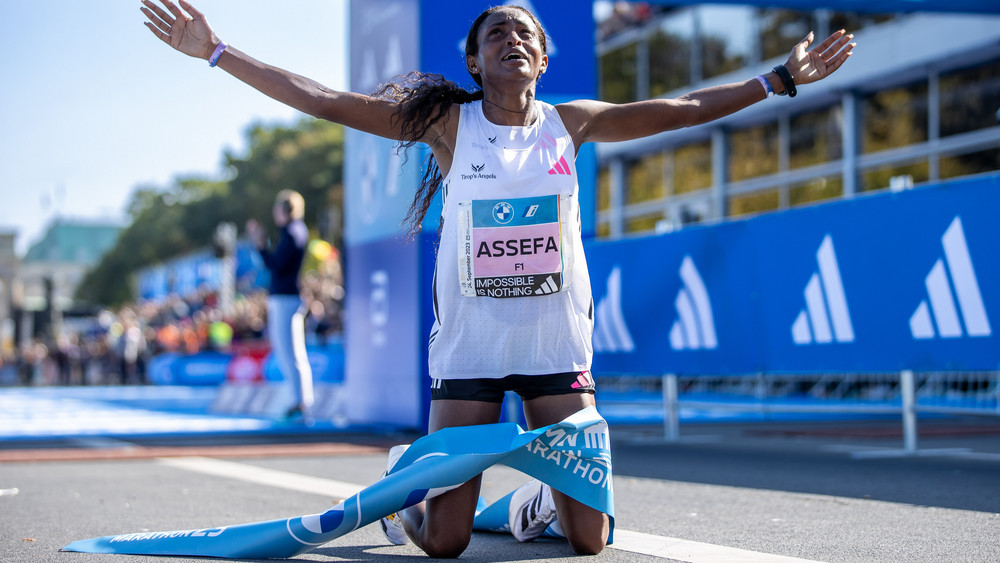 Tigist Assefa aus Äthiopien kniet am Boden nach ihrem Erfolg beim BMW Berlin Marathon. 