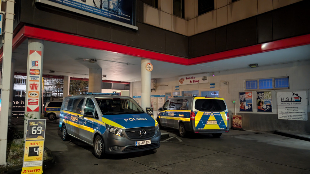 Eine Tankstelle in Darmstadt, umstellt von mehreren Polizeiwagen