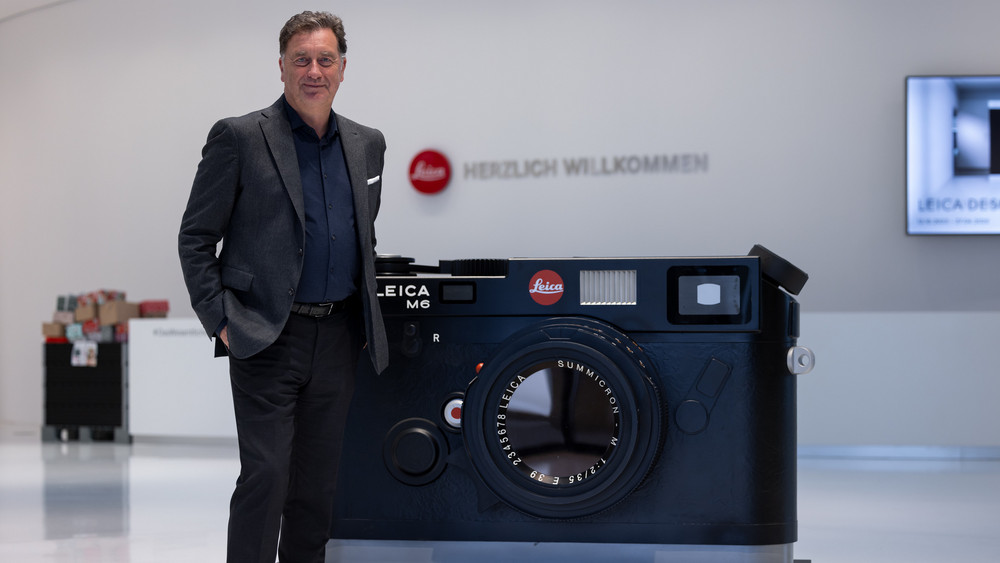 Matthias Harsch ist seit 1. September 2017 der Vorstandsvorsitzende der Leica Camera AG. Im Foyer der Firmenzentrale steht er neben einem für die Photokina 1994 geschaffenen, überdimensionalen Messemodell einer Leica M6-Kamera. 