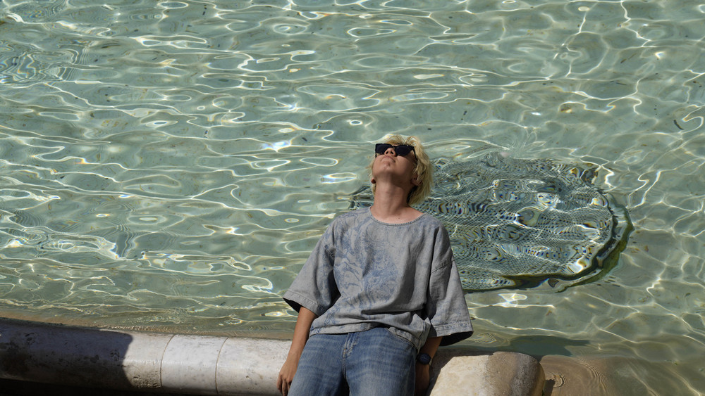 Ein Mann sitzt am Trevi-Brunnen in Rom, während die Temperaturen bis zu 39 Grad Celsius erreichen.