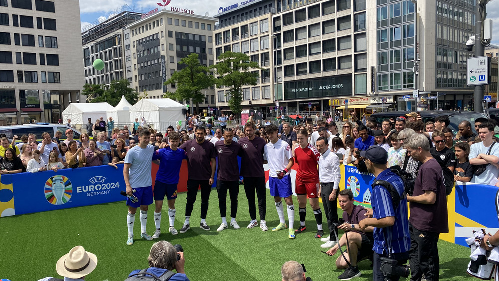 Emre Can, Leroy Sané und Kevin Trapp (Mitte) sowie Oberbürgermeister Mike Josef (links) posieren für ein Gruppenfoto an der Hauptwache.