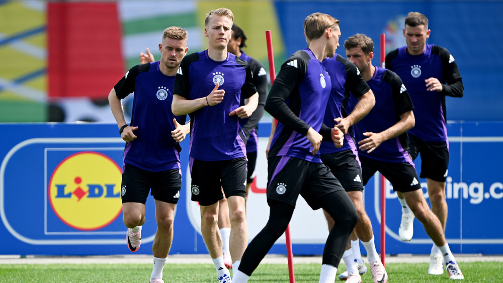 Maximilian Mittelstädt (l) und Chris Führich (2vl) laufen während des Trainings mit ihren Mitspielern über den Rasen.
