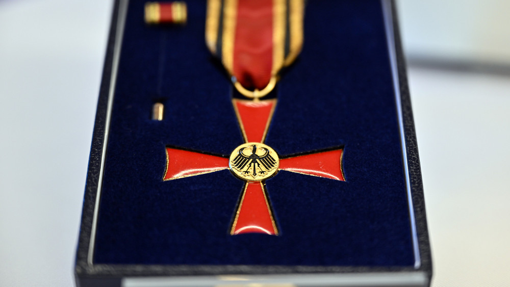 Das Verdienstkreuz am Bande liegt auf einem Tisch. Bürgerinnen und Bürger erhalten Verdienstorden der Bundesrepublik Deutschland im Namen des Bundespräsidenten