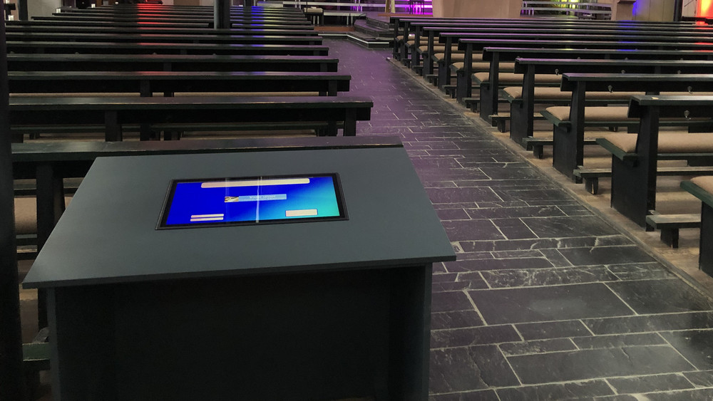 Ein Terminal mit eingebautem Touchscreen steht im hinteren Teil der Kirche.