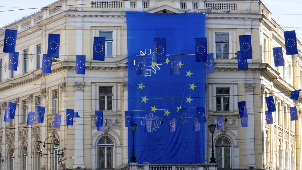 Eine riesige Flagge der Europäischen Union hängt an einem Gebäude, während kleinere Flaggen eine Hauptstraße in Sarajevo schmücken. Die EU hat den Start von Beitrittsverhandlungen mit dem Balkanland Bosnien-Herzegowina beschlossen.