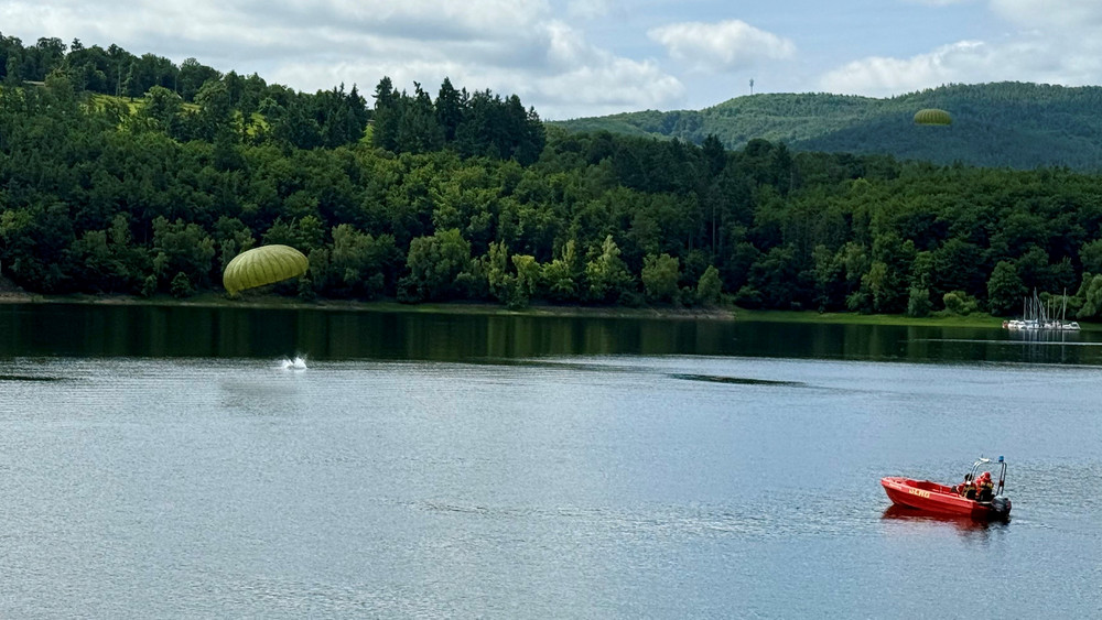 Fallschirmspringer der Bundeswehr landen bei einer Übung im Edersee.