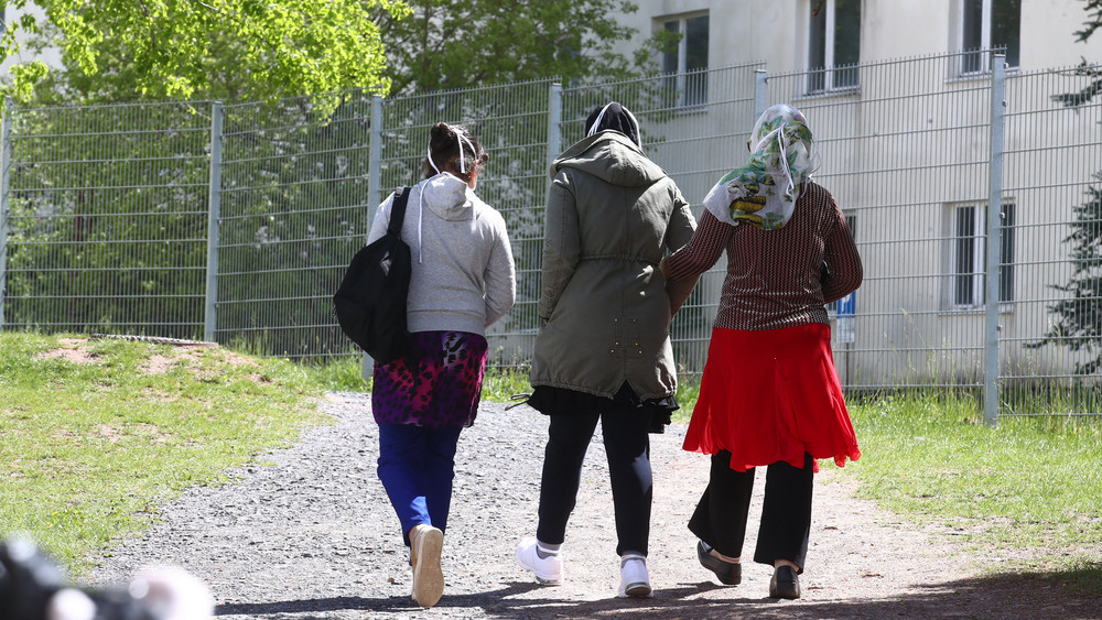 Asylbewerber gehen auf dem Gelände einer Erstaufnahmeeinrichtung spazieren.