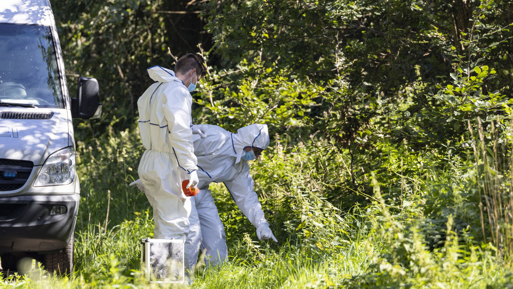 Beamte der Spurensicherung untersuchen den Auffindeort der Leiche nahe einer Tankstelle unmittelbar an der deutsch-niederländischen Grenze.