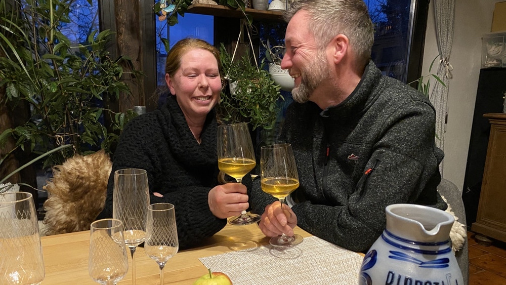 Ehepaar am Esstisch mit den Weingläsern