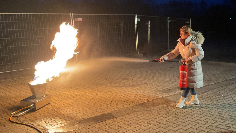 Selbst ausprobiert: Beim Besuch der Feuerwehr löschen die Dolmetscher ein Brand mithilfe eines Feuerlöschers.