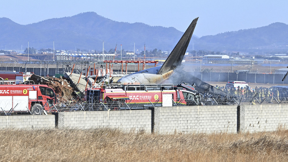 Feuerwehrleute und Mitglieder eines Rettungsteams arbeiten auf der Start- und Landebahn des internationalen Flughafens Muan. Bei der Landung am internationalen Flughafen von Muan in Südkorea ist ein Passagierflugzeug verunglückt.