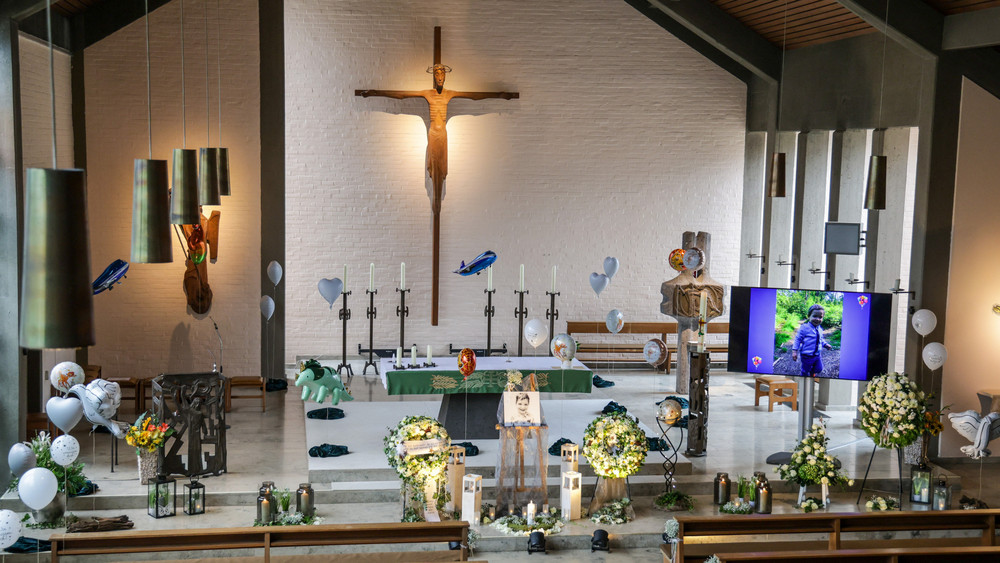 Auf einem Bildschirm in der Kirche wurden Fotos aus dem Leben des autistischen Kindes gezeigt.