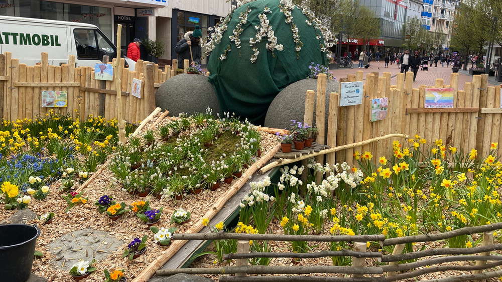 Der Gießener Kugelbrunnen ist frühlingshaft mit Blumen geschmückt