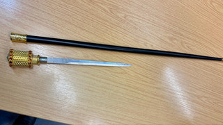 Flughafen: Mann mit Stockdegen an Passagierkontrolle