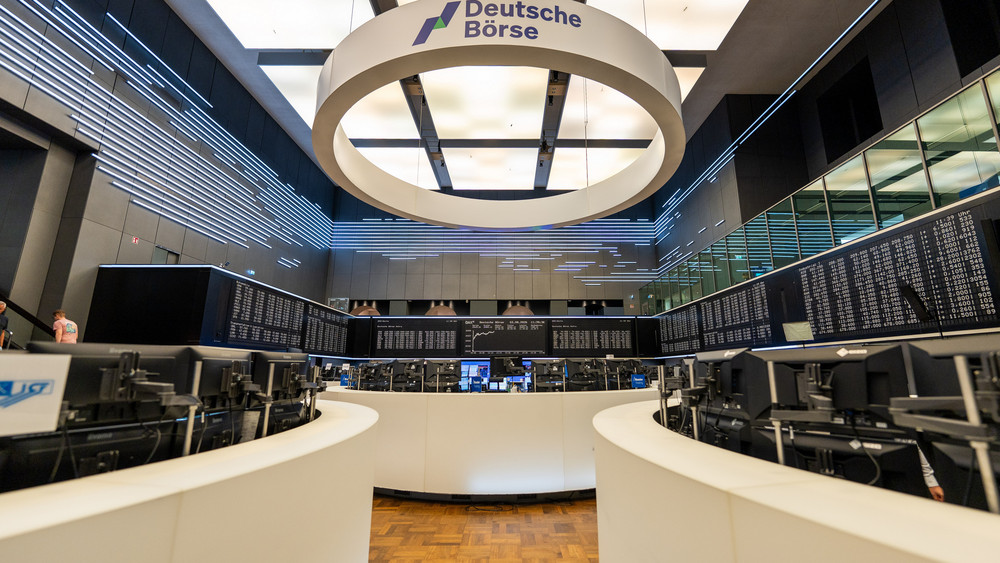 Im Handelssaal ist ein großer Ring mit der Aufschrift Deutsche Börse aufgehängt.