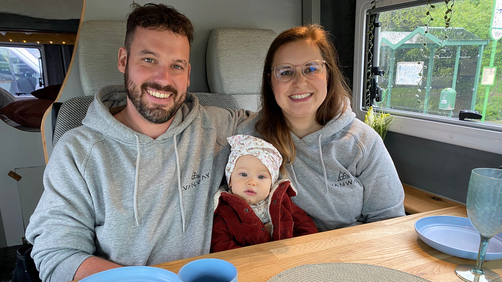 Chris, Sina und ihre Tochter Lotte in ihrem Van sitzen am Tisch