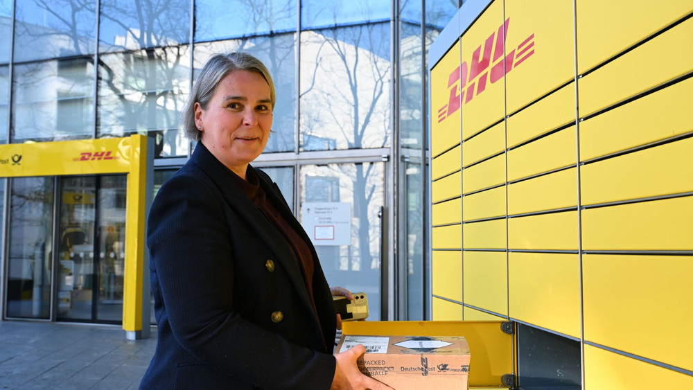DHL-Vorstandschefin Nikola Hagleitner steht vor einer Abholstation