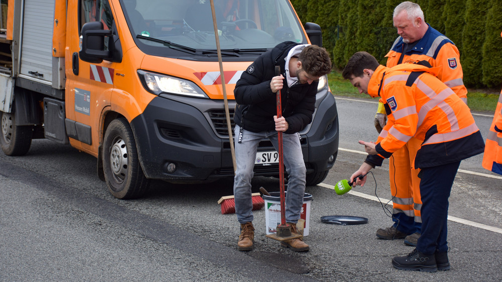 FFH-Reporter Marius Franke legt Hand an. Unter Beobachtung von Streckenwart Sascha Weiß und Eric Seitel aus der Presseabteilung von Hessen Mobil.