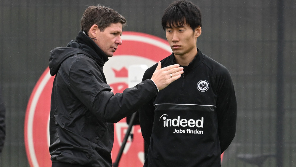 Cheftrainer Oliver Glasner (l) spricht mit Daichi Kamada.
