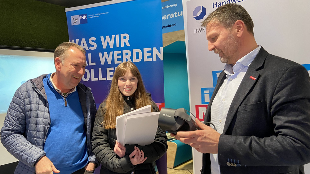 Im Pop-up-Store in Kassel können Interessierte sich etwa mit Hilfe einer VR-Brille anschauen, was in verschiedenen Handwerksberufen genau gemacht wird. Das Bild zeigt IHK-Sprecher Thomas Rudolff (von links), Azubi Leonie Weis und Andreas Schönebeck von der Handwerkskammer .haben 