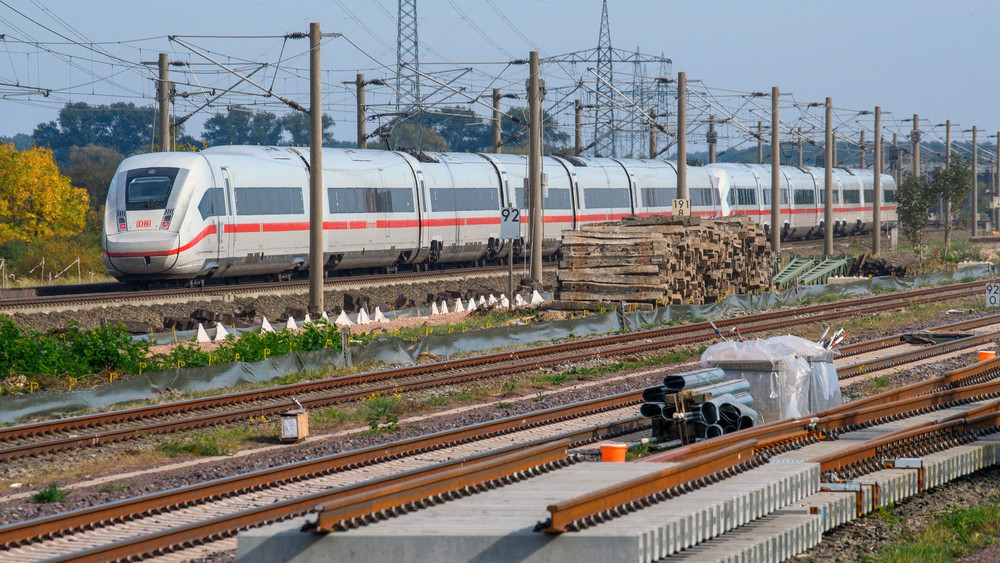 ICE rollt nahe des Bahnhofs Schönhausen an Gleisbauteilen vorbei