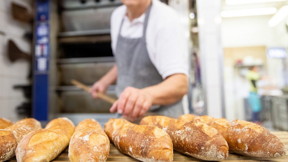 Ein Bäcker holt Brot aus dem Ofen - doch im Bäckerhandwerk fehlt der Nachwuchs.