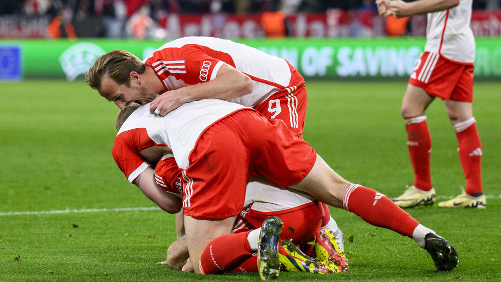 Münchens Harry Kane jubelt nach dem Spiel mit Münchens Eric Dier und Münchens Leon Goretzka.