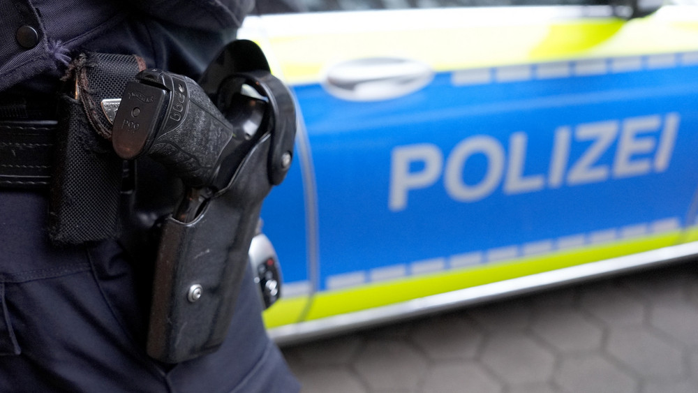 Polizist und Streifenwagen Symbolbild