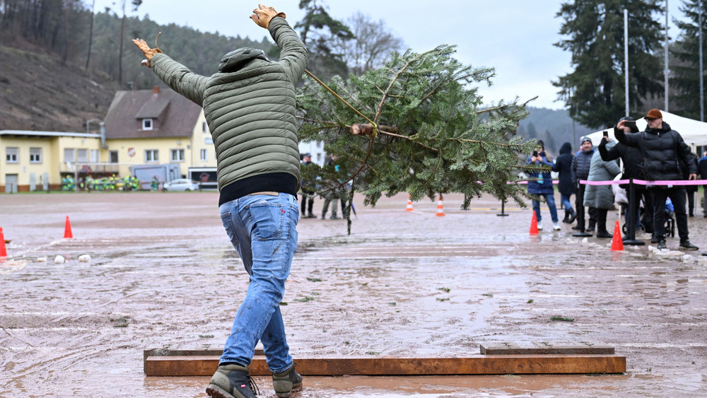 Ein Teilnehmer schleudert bei der 17. Weltmeisterschaft im Weihnachtsbaumwerfen einen Baum. Die vom Verein FC Wacker Weidenthal gegründete "Weltmeisterschaft" wird im Dreikampf ausgetragen: Weitwurf, Hochwurf und Schleuderwurf eines ungefähr 1,50 Meter großen Baums.