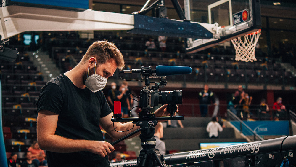 Filmemacher aus Gießen dreht mit seiner Kamera in einer Basketballhalle