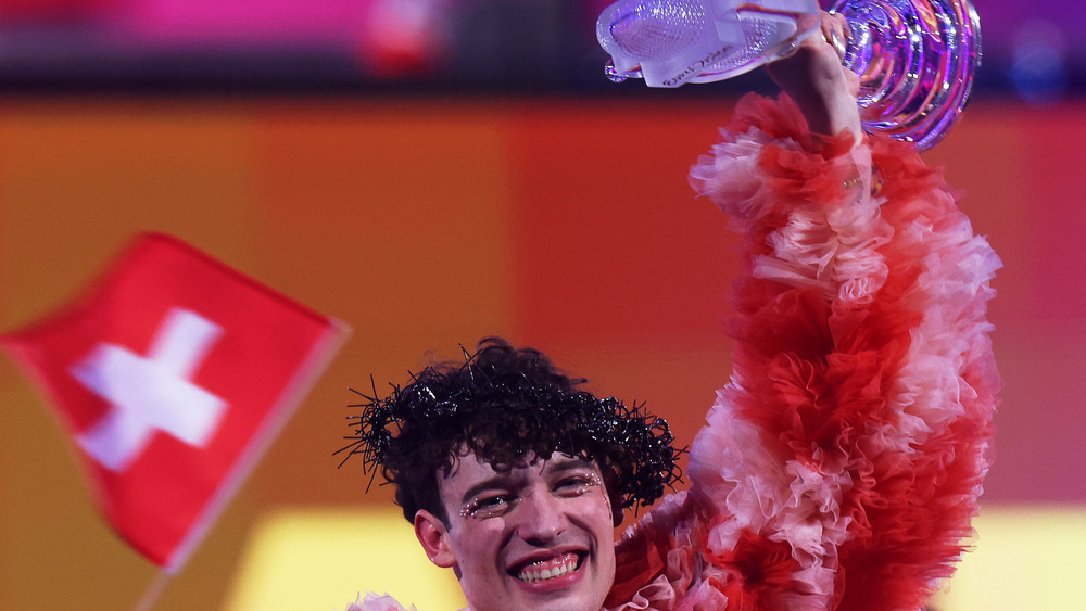 Nemo aus der Schweiz jubelt mit der Trophäe über den Sieg beim Finale des Eurovision Song Contest (ESC) 2024 in der Malmö Arena.