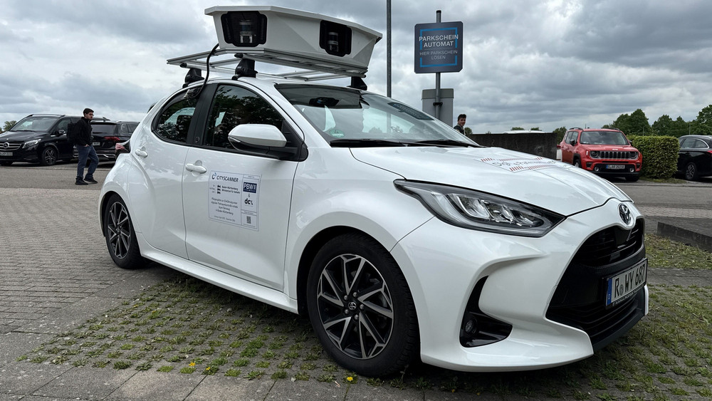Ein Kleinwagen mit einem Kamerasystem auf dem Dach zur Erkennung von Parksündern steht auf einem Parkplatz. Es handelt sich um ein Test-Fahrzeug der Universität Hohenheim