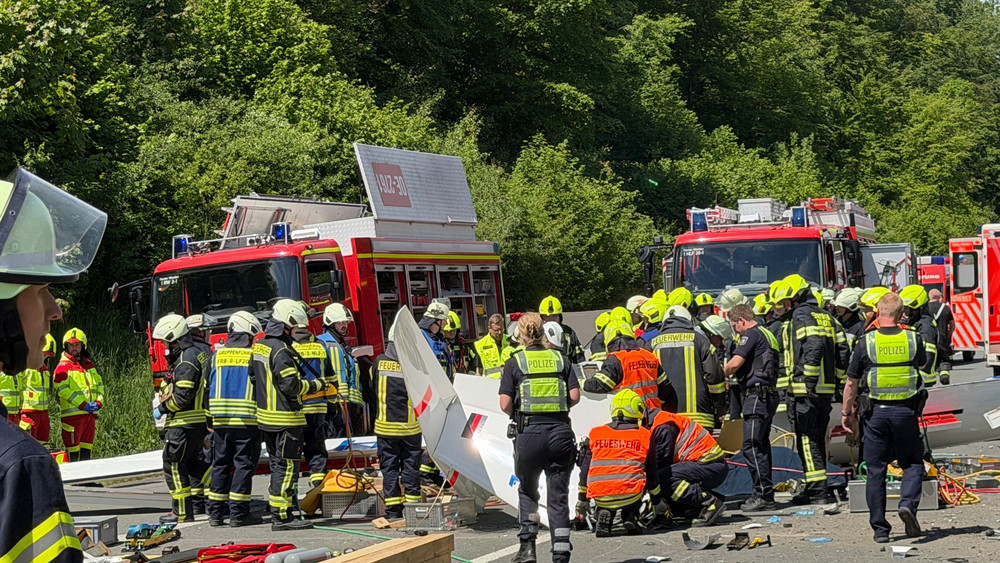 Rettungsdienste und Polizei arbeiten an der Unfallstelle, nachdem bei Olpe ein Segelflugzeug auf die A45 gestürzt ist.