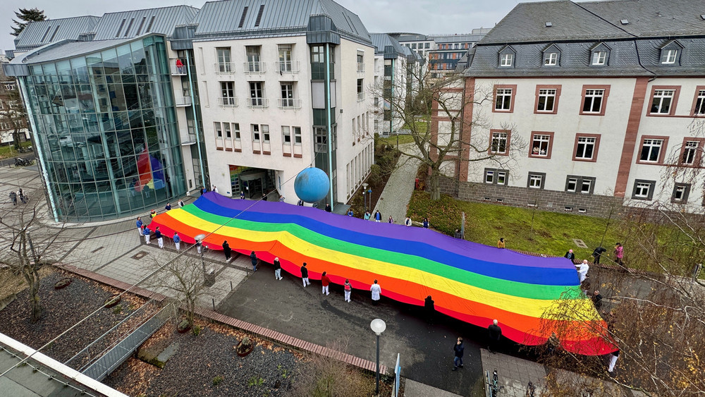 Rund 30 Mitarbeiterinnen und Mitarbeiter des UKGMs haben als Zeichen für Vielfalt und Offenheit eine riesige Regenbogenflagge entfaltet. 