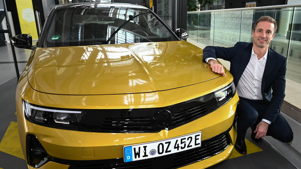 Florian Huettl, Geschäftsführer der Opel Automobile GmbH, in der Unternehmenszentrale in Rüsselsheim neben einem Opel Astra 
