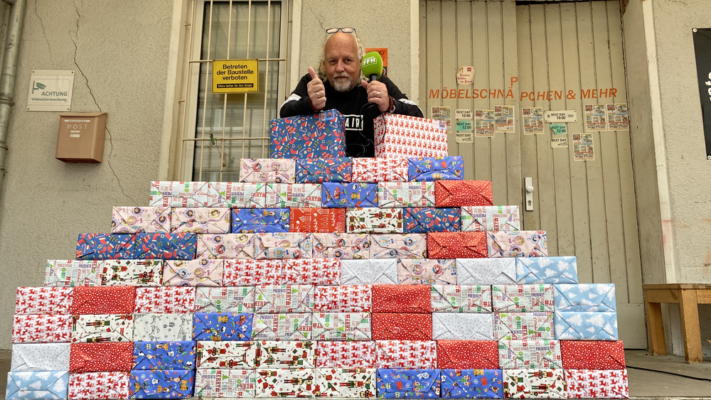 Markus Machens hinter einem Berg von bunt eingepackten Geschenken für die Obdachlosen.
