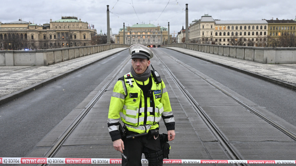 Ein Polizist steht auf der gesperrten Mánes-Brücke. An einer Hochschule in der Prager Innenstadt sollen Schüsse gefallen sein.