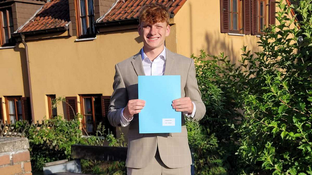 Johannes zeigt stolz sein Abizeugnis