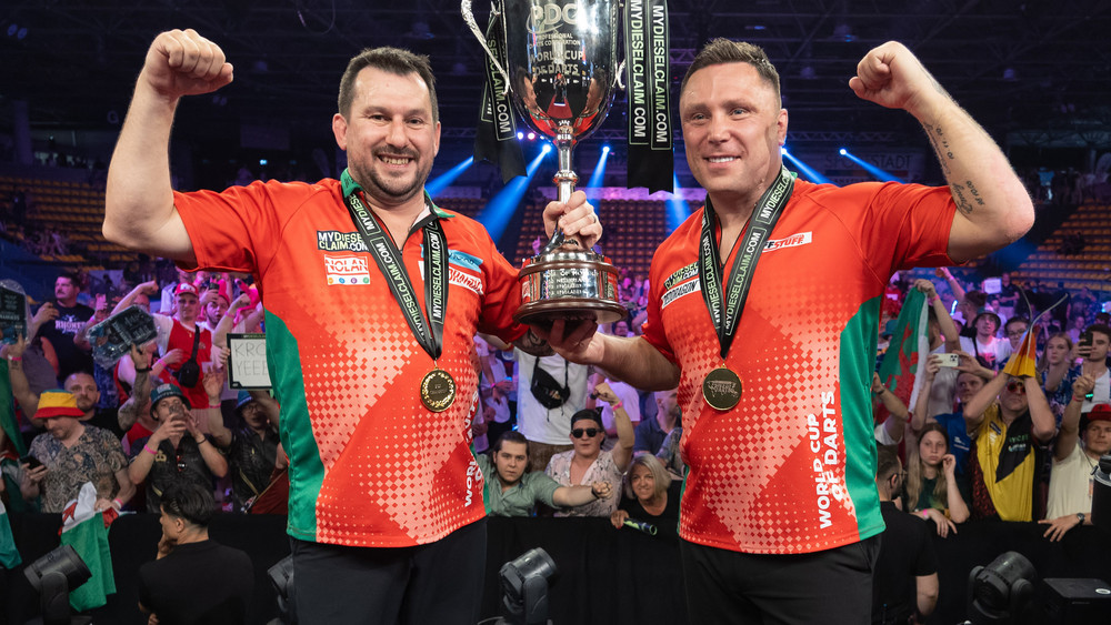 Die neuen Weltmeister Jonny Clayton (Wales, l) und Gerwyn Price (Wales) halten ihren Pokal hoch. Die Deutschen Gabriel Clemens und Martin Schindler schieden im Halbfinale aus.