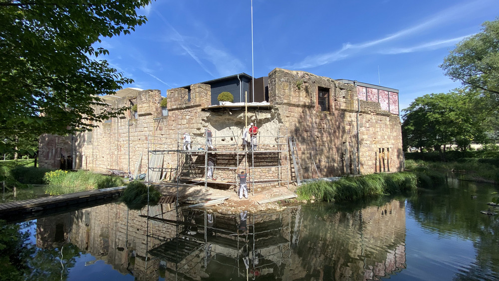 Die Mauer an der Wasserburg in Bad Vilbel soll bis zum Hessentag wieder vollständig stehen. Danach und nach den Burgfestsspielen sollen dann nur noch kleine Feinarbeiten gemacht werden.
