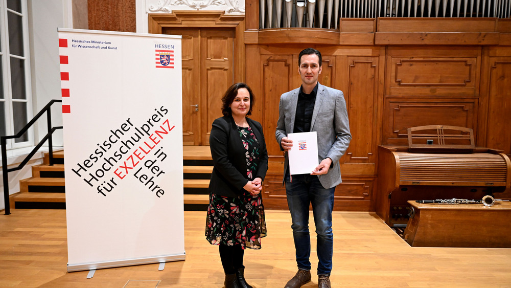 Staatssekretärin Ayse Asar (links) mit Preisträger Vincent Felde (rechts), bei der Verleihung des Hessischen Hochschulpreises.