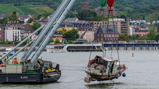 Schwimmkran rettet gestrandetes Sportboot aus dem Rhein