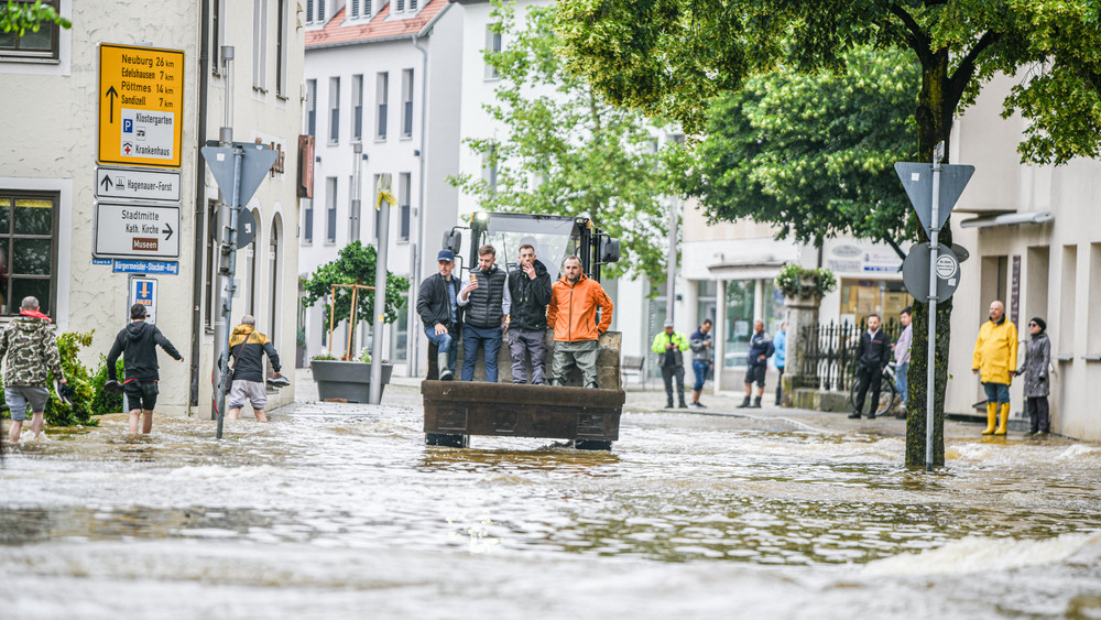 Mit einem Radlader werden Menschen aus den Fluten gerettet.